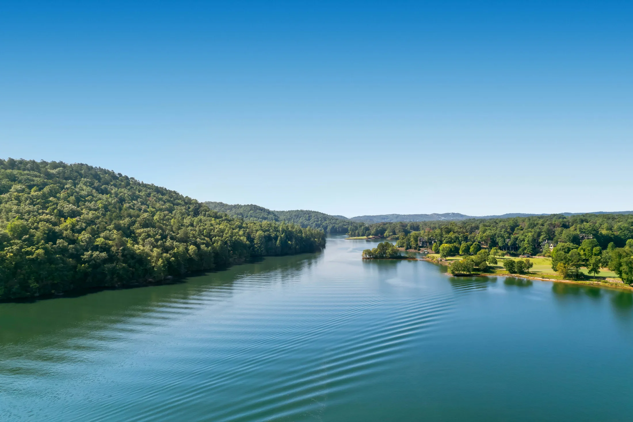 Aerial view across the blue water and wooded shoreline of Lake Keowee, South Carolina